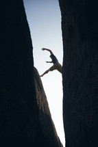 man leaping across two cliffs 