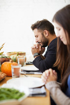praying before thanksgiving meal 