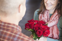 woman  receiving roses from her husband