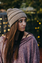 a young woman in a beanie standing outdoors 