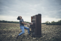 a man playing a piano in a field 