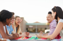 friends talking around an outdoor table 