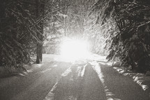 glowing headlights from a four wheeler in the snow 