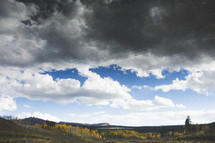 gray clouds over rolling hills 