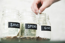 placing money in Give, Save, Spend money jars