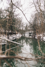 Snow falling over an icy river in winter