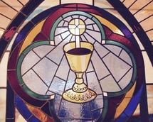 A stained glass window depicting the Eucharist 