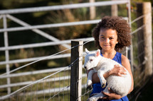 a girl holding a lamb 