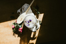 flowers, wooden spoon, and glass mug in a sunspot 