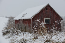 snow on a red barn 