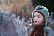 toddler boy standing outdoors in winter 