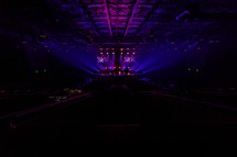 Colorful stage lights shining on a stage and large auditorium.