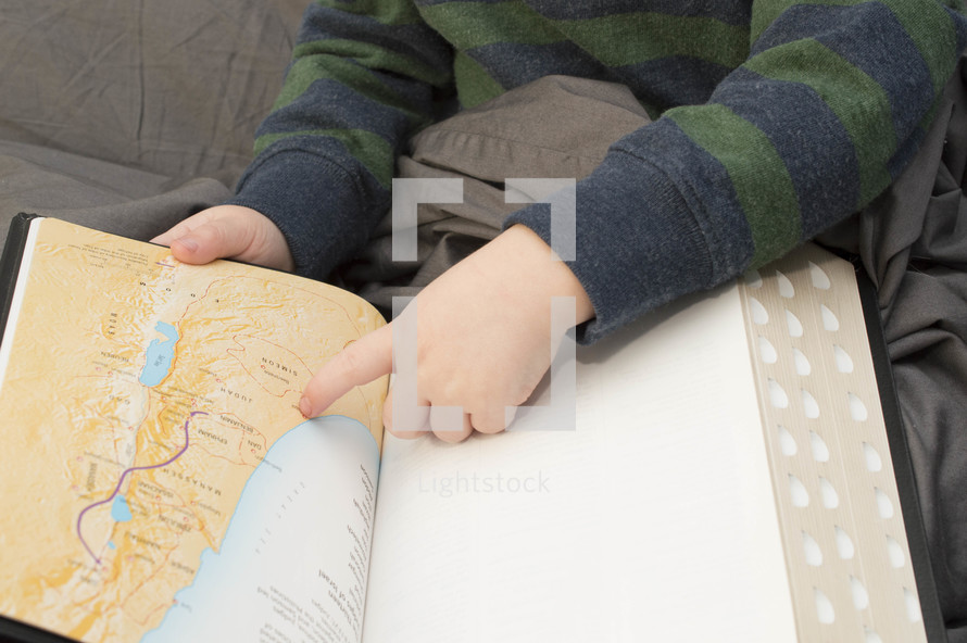 toddler finger pointing to a map of the middle east in a Bible 
