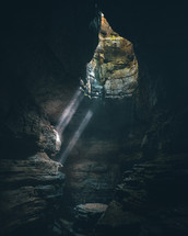 rays of sunlight shining into a cave 