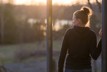 teen girl standing outdoors at sunset 