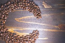 Coffee beans shaped in the letter C on a wooden background. Decorative banner for coffee products.