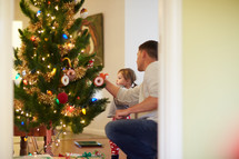 father and daughter decorating a Christmas tree