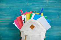 colorful school supplies in a book bag