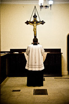 priest standing before an altar 