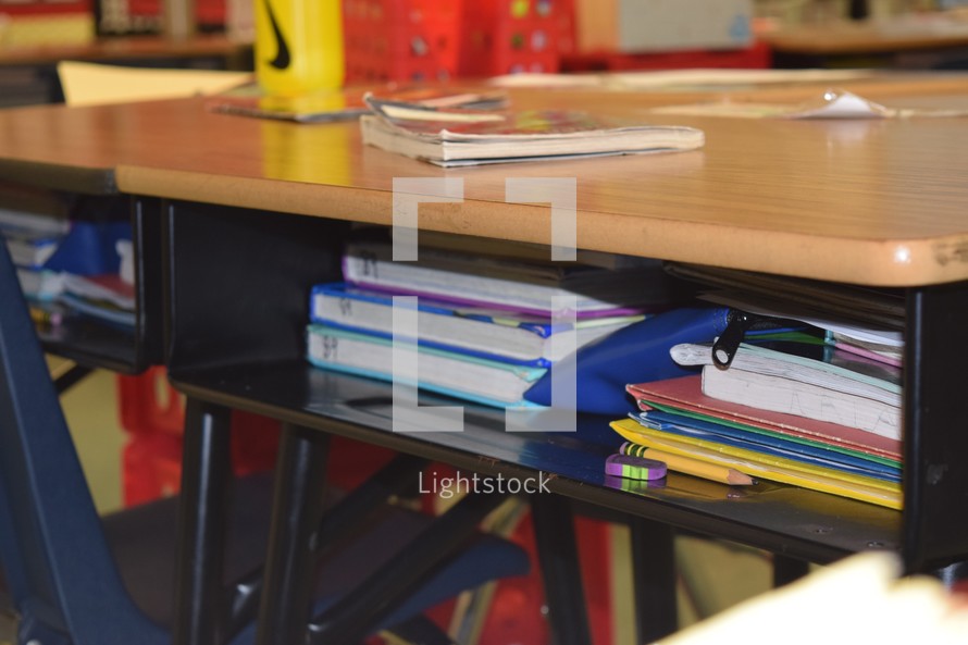 books and folders in a student desk 