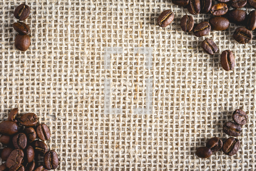 Bunch of Coffee beans laying on burlap fabric. Background voor coffee related products.