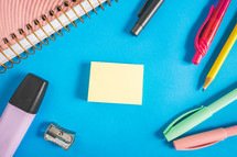 Different kind of school/office supplies for studying, on a blue background. Back to school.