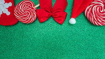 Flatlay of some red Christmas decoration, on a green background. Background for Christmas.