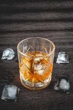 A beautiful glass of wiskey on the Rocks, on a black background. whiskey with ice cubes.