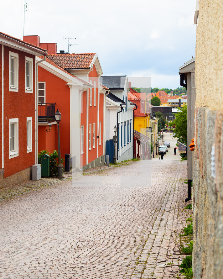 A cobblestone street running down through a city 