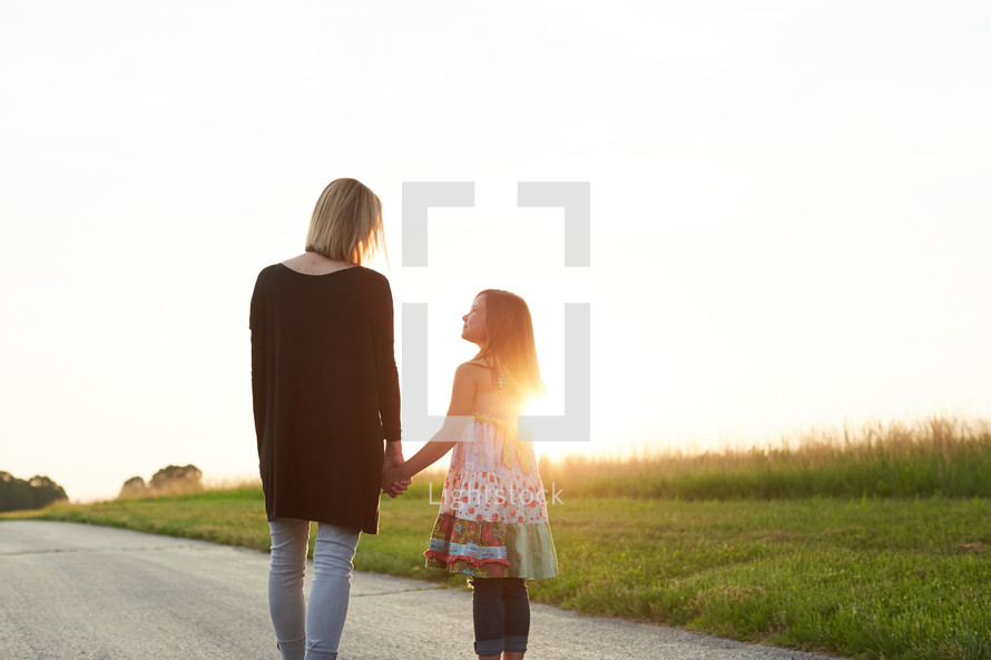 a mother and daughter talking outdoors at sunset 