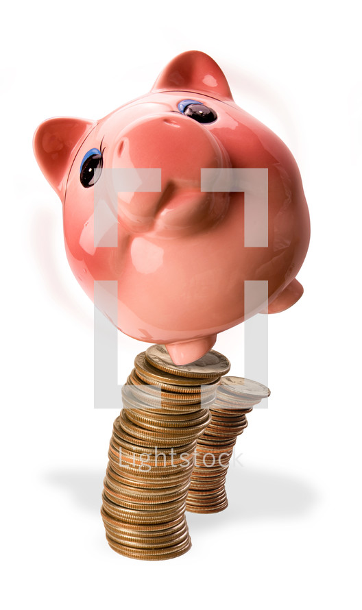 Piggy bank balancing on a stack of coins 