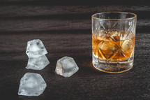 A beautiful glass of wiskey on the Rocks, on a black background. whiskey with ice cubes.