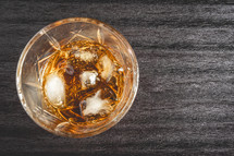 A beautiful glass of wiskey on the Rocks, on a black background. whiskey with ice cubes.