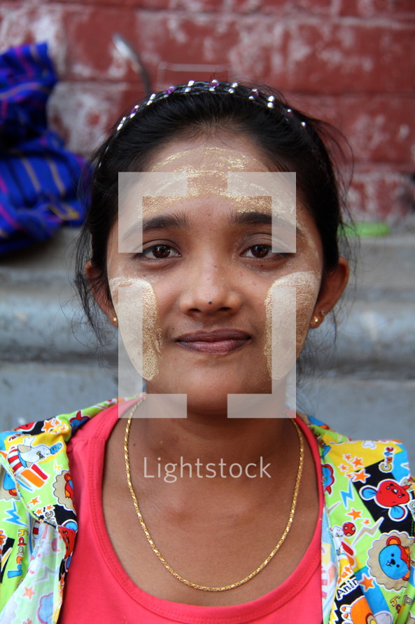 Myanmar woman with traditional 'thanaka' paste applied to her face.