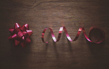 a red bow and ribbon on wood