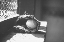 baseball in a glove in a dugout 