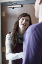 A man and woman in conversation in front of a door 