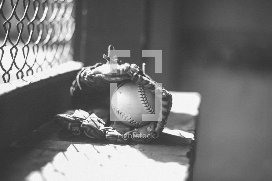 baseball in a glove in a dugout 