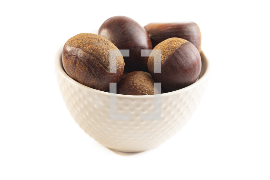 Bowl of hazelnuts on a white background