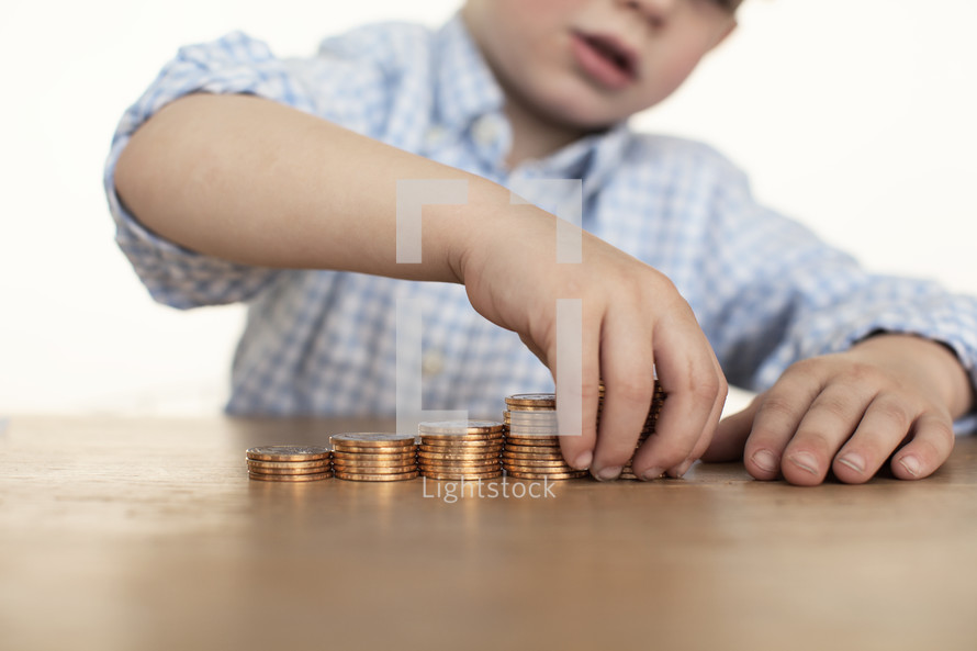 child stacking gold coins