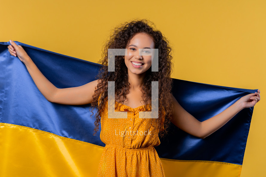 Smiling woman with national Ukrainian flag. Ukraine, patriot, victory in war celebration, banner, Independence day. High quality photo