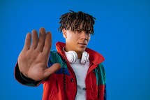 Serious african man showing rejecting gesture by stop palm sign. Dont play with me. Guy isolated on blue background. High quality. High quality photo
