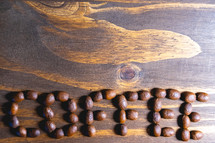 Coffee beans shaped in the letters coffee on a wooden background. Decorative banner for coffee products.