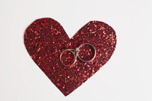 wedding rings on a red heart cut-out 
