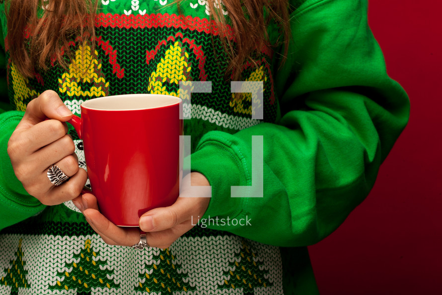 a woman in a Christmas sweater t-shirt holding a mug 