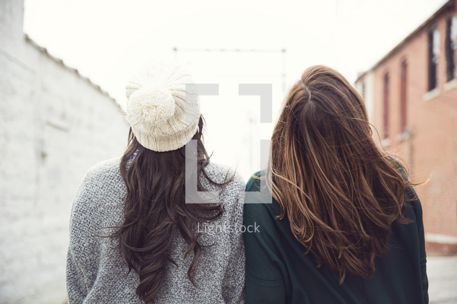 back of two girl's heads looking up. 