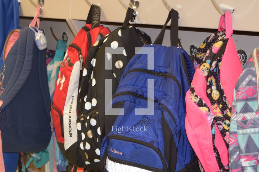 book bags hanging on hooks in an elementary school classroom 