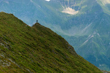a man on a green mountain peak 