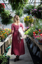 a woman picking out flowers in a garden center 