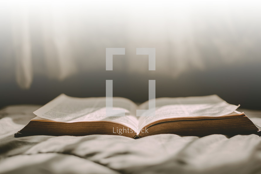 open Bible on a bed 